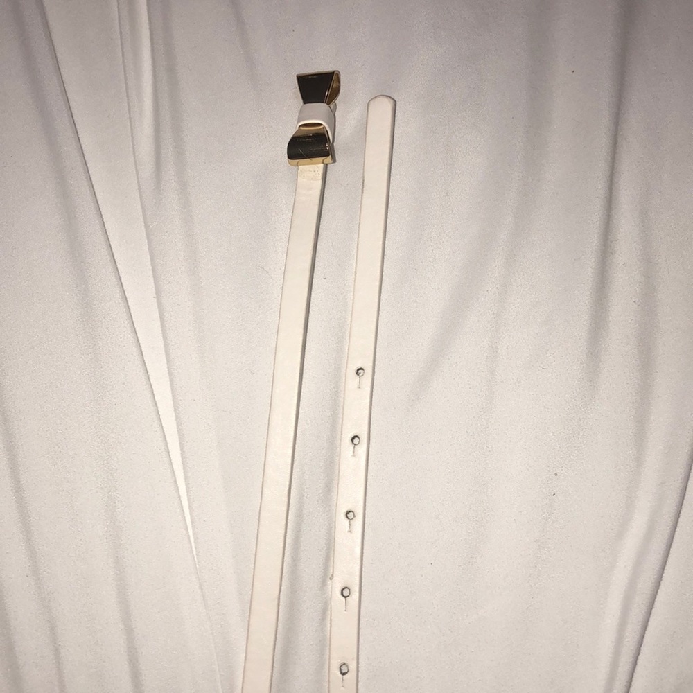 White faux leather waist belt with bow accent.